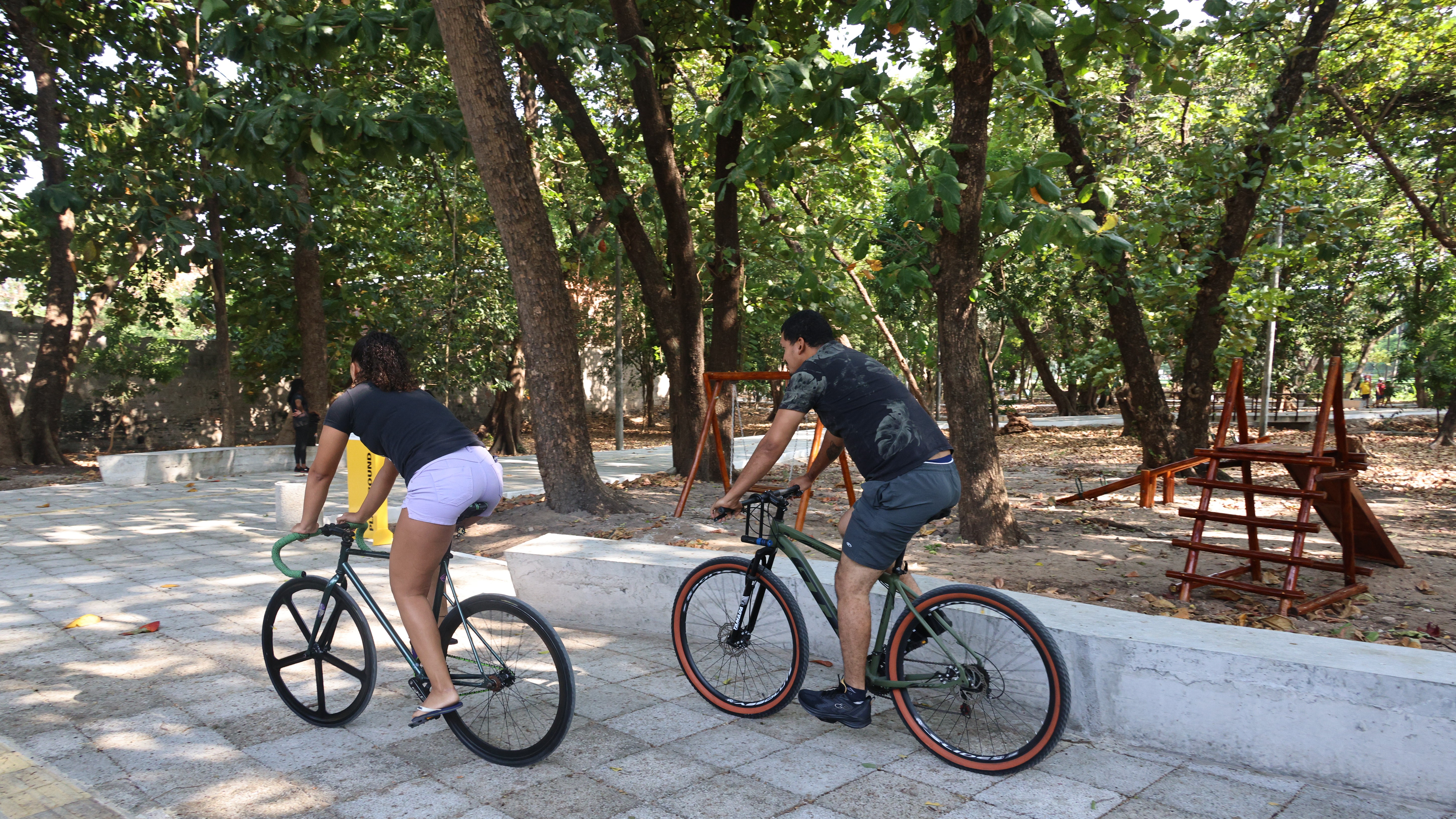 um homem e uma mulher andam de bicicleta no parque rio branco